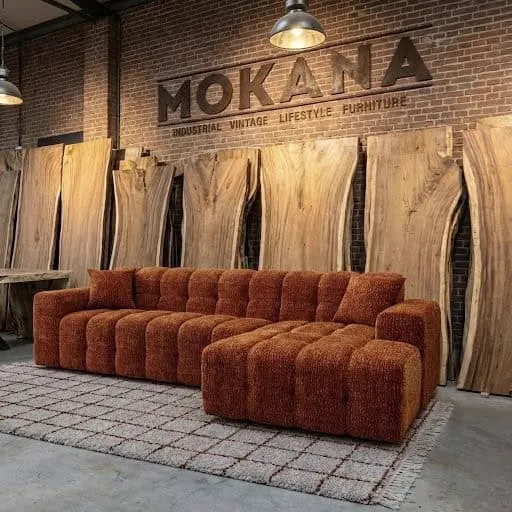 Loungesofa Bree auf einem karierten Teppich in einem Studio mit Holzbrettern und Ziegelwand - Primavera