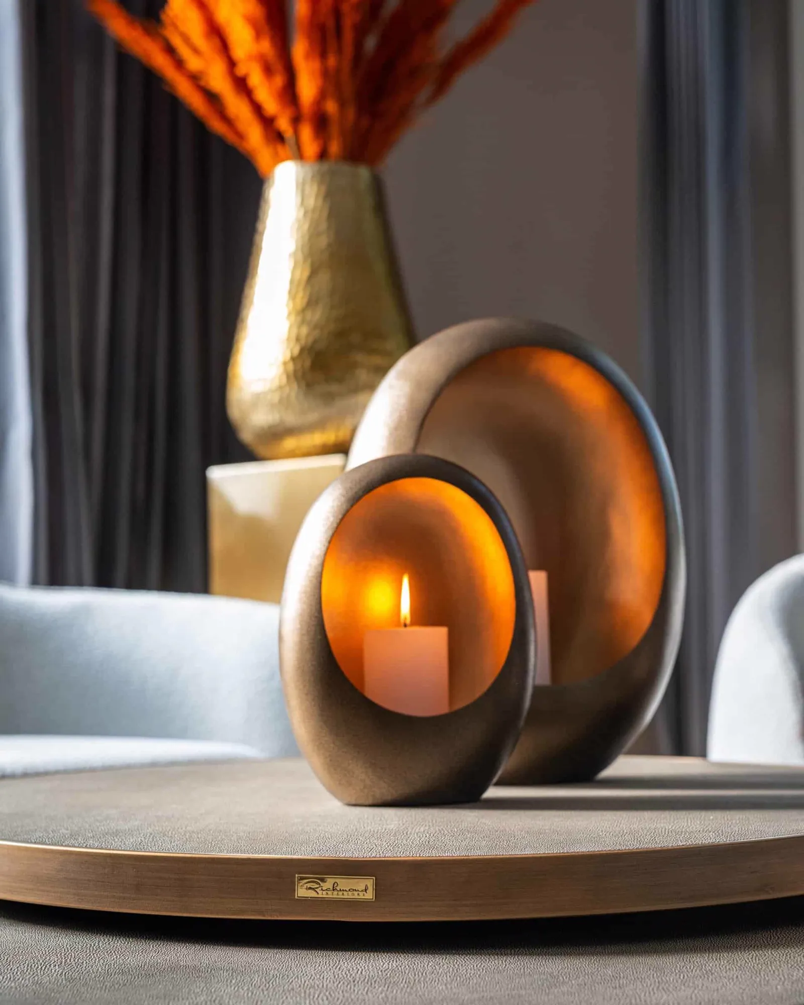 Couchtisch Bloomville brass shagreen 2er-Set mit Kerzenhaltern und orangefarbenen Federn in einer goldenen Vase - Richmond Interiors