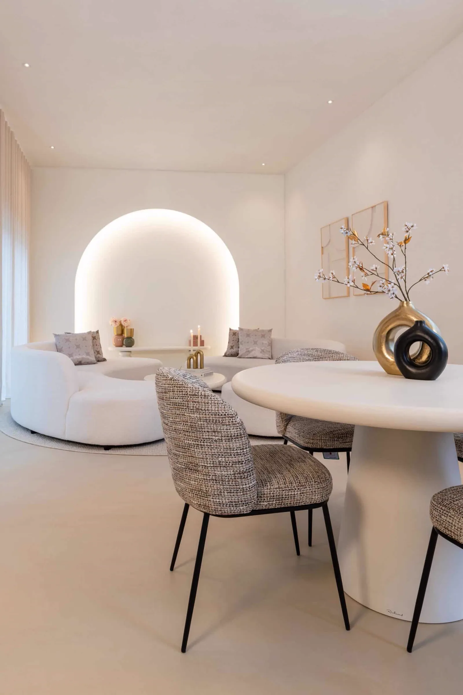 Esszimmerstuhl Elvi in einem modernen Wohnzimmer mit runder Couch und Esstisch, aus niedriger Perspektive - Richmond Interiors