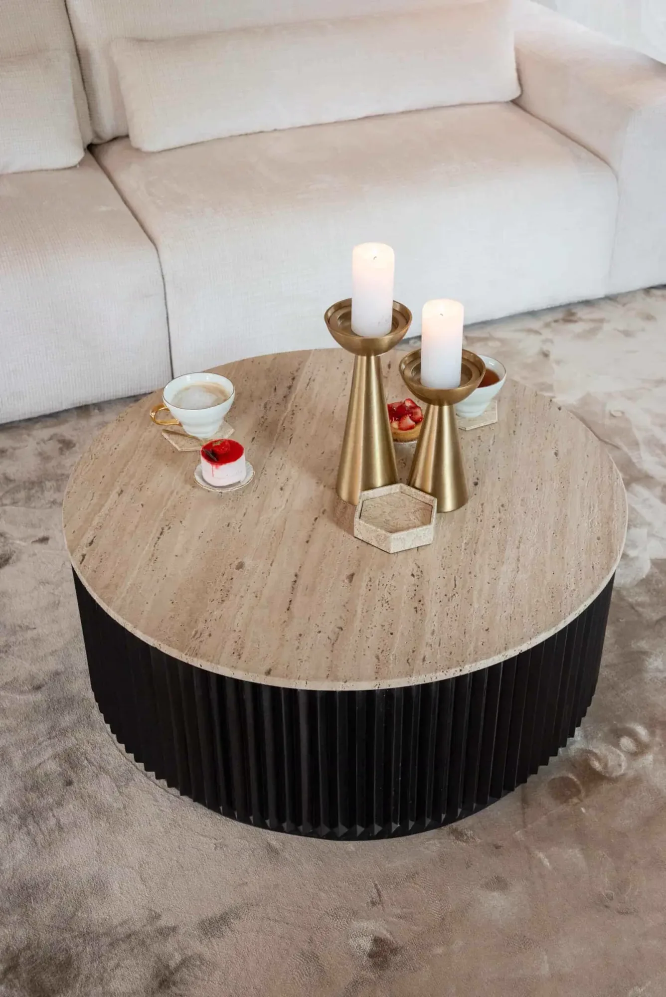 Couchtisch Hampton dunkelbraun 90Ø in einem hellen Wohnzimmer mit Sofa, Teppich, Kerzen und Gebäck - Richmond Interiors
