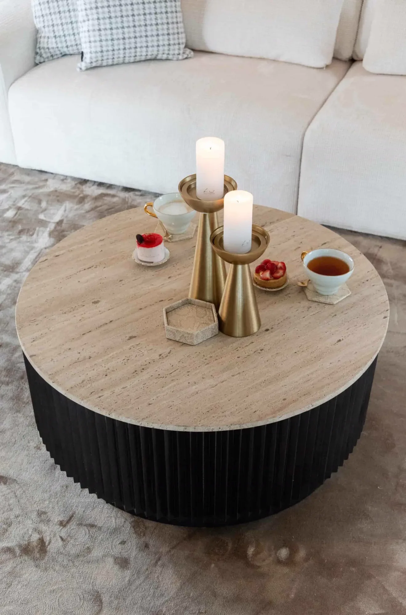 Couchtisch Hampton dunkelbraun 90Ø in einem hellen Wohnzimmer mit einem Sofa, Teppich, Kerzen und Gebäck - Richmond Interiors