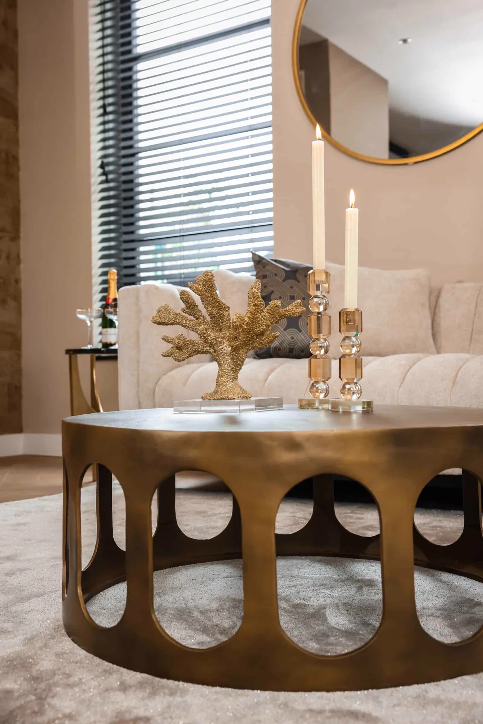 Couchtisch Du Pont brushed gold in einem stimmungsvollen Wohnzimmer mit Kerzen und goldener Korallendekoration - Richmond Interiors
