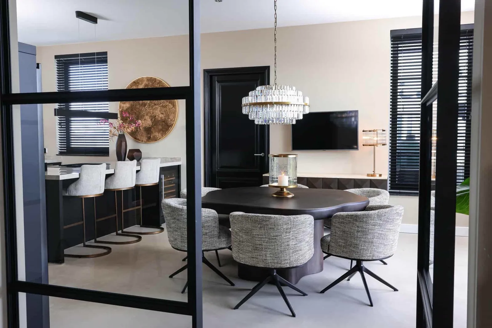 Tischleuchte Loiza Brushed Gold auf einem Sideboard in einem modernen Wohnzimmer mit dunklen Jalousien und einem Fernseher - Richmond Interiors