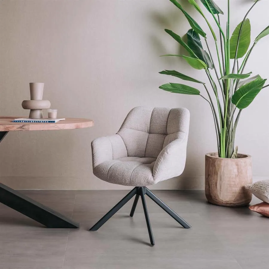 Der Alba Armstuhl - Alpine Naturel 01 (drehbar) in einem hellen Wohnzimmer neben einem Holztisch und einer großen Pflanze - Tower Living