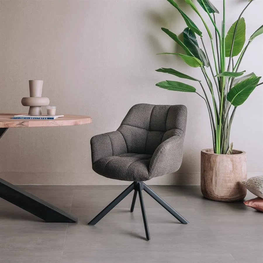 Der Alba Armsessel in Alpine dark brown 18, drehbar, steht in einem modernen Ambiente neben einem Holztisch und einer Pflanze - Tower Living