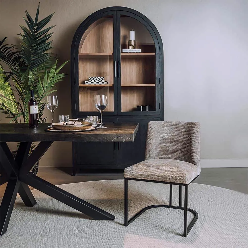 De Archi Stoel - fabric Eden 4 beige staat aan een houten tafel in een eetkamer - Tower Living