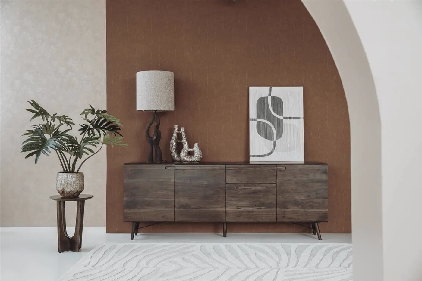 Aura Sideboard Espresso 210 cm in einem stimmungsvollen Wohnzimmerambiente mit Pflanze und Lampe - Tower Living