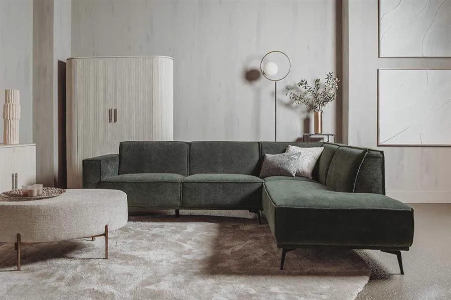 De Leeds 2.5-AL + Ottoman R - City 355 Bottle Green bank in een sfeervolle woonkamer met vloerkleed en salontafel - Tower Living