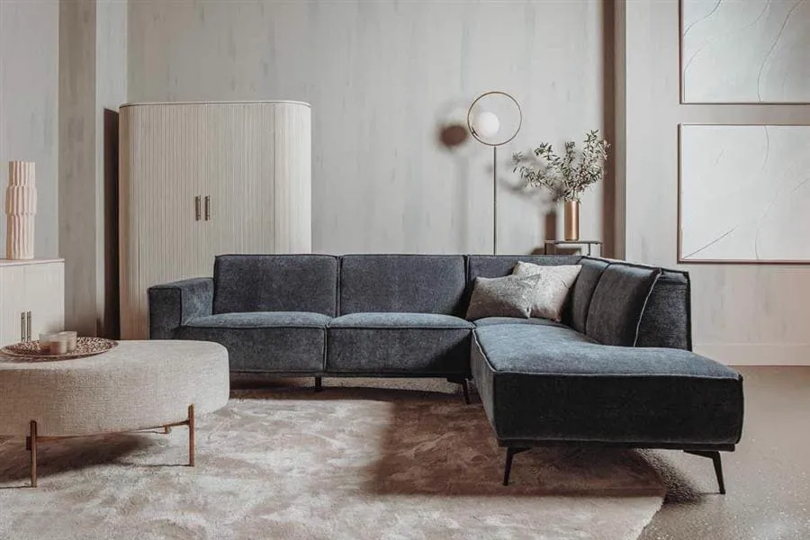De Leeds 2.5-AL + Ottoman R - City 464 Black Blue bank in een modern interieur met een rond vloerkleed - Tower Living