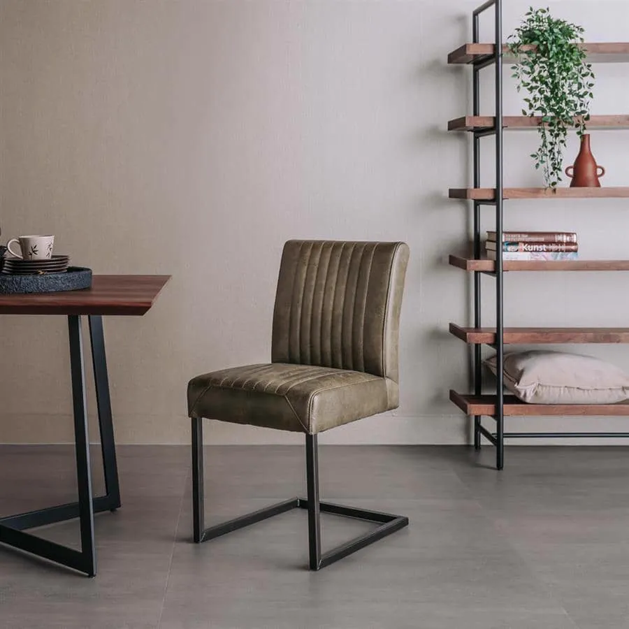 Der Ferro Stuhl - Stoff Savannah green steht in einem modernen Studio mit einem Holztisch und einem offenen Regal - Tower Living