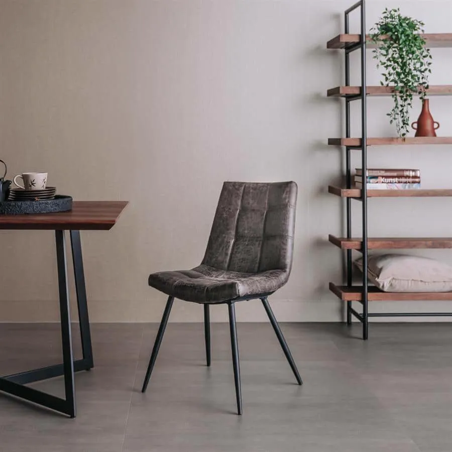De Navarra Stoel - fabric Antracite staat in een moderne eetkamer met een houten tafel en een open kast - Tower Living