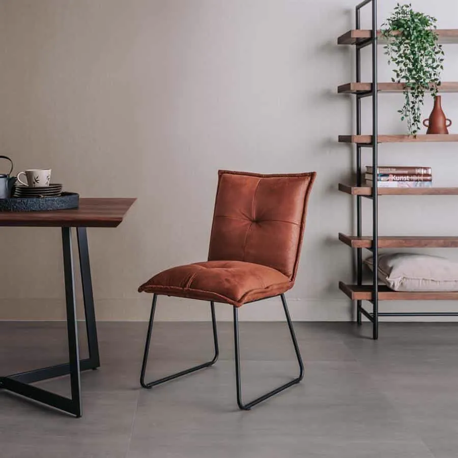 De Seda Stoel - fabric Cherokee 8 cognac staat in een woonkamer bij een eettafel en een open kast - Tower Living