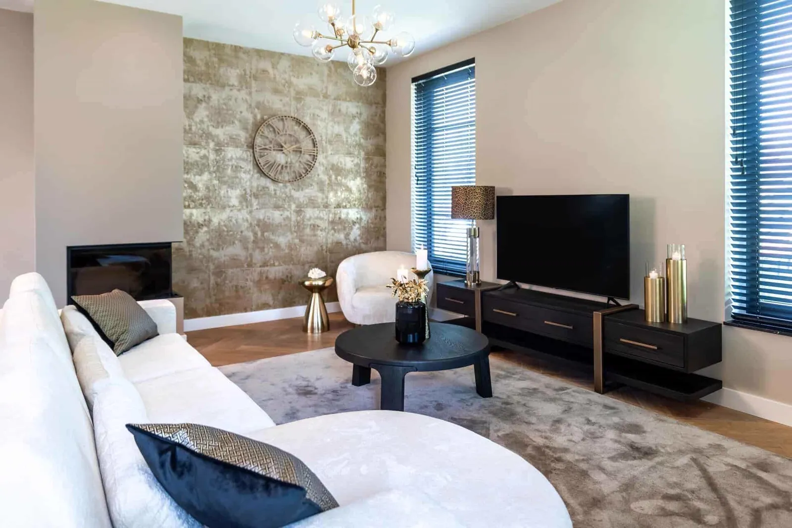 Das TV-Sideboard Cambon dark coffee in einem modernen Wohnzimmer mit einem weißen Sofa und einem runden Couchtisch - Richmond Interiors