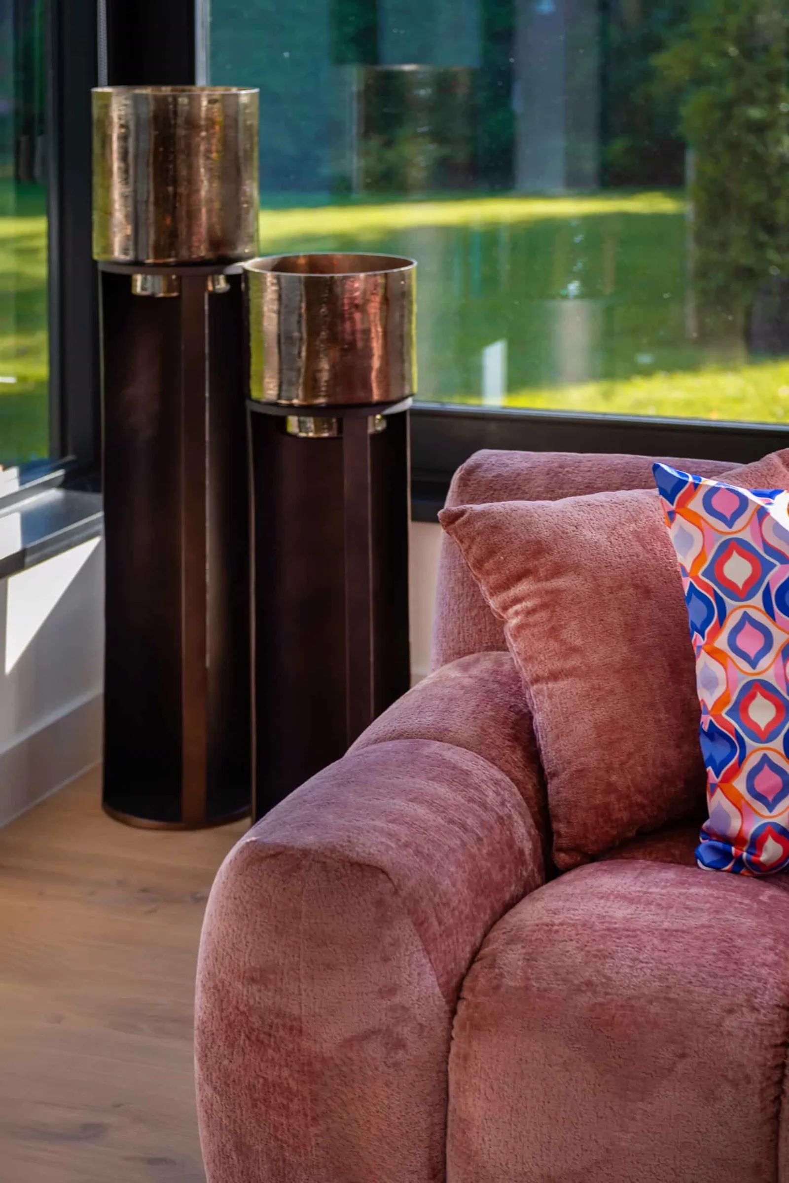Sofa Charelle rose chenille in einem modernen Wohnzimmer mit zwei hohen, bronzenen Vasen und einem gemusterten Kissen - Richmond Interiors