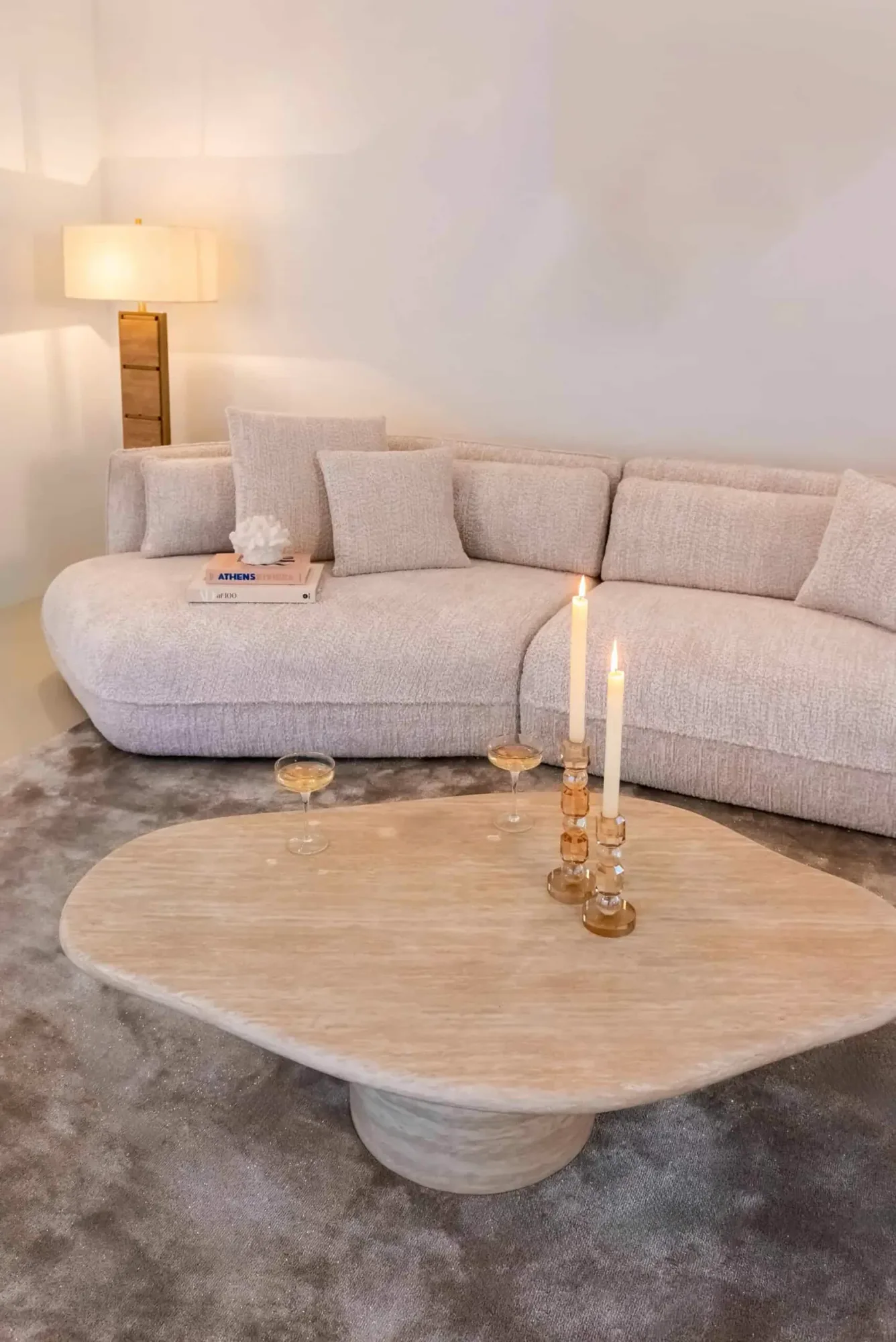 Der Couchtisch Fictus beige 130 in einem hellen Wohnzimmer mit Sofa und Teppich, aus einer niedrigen Perspektive - Richmond Interiors
