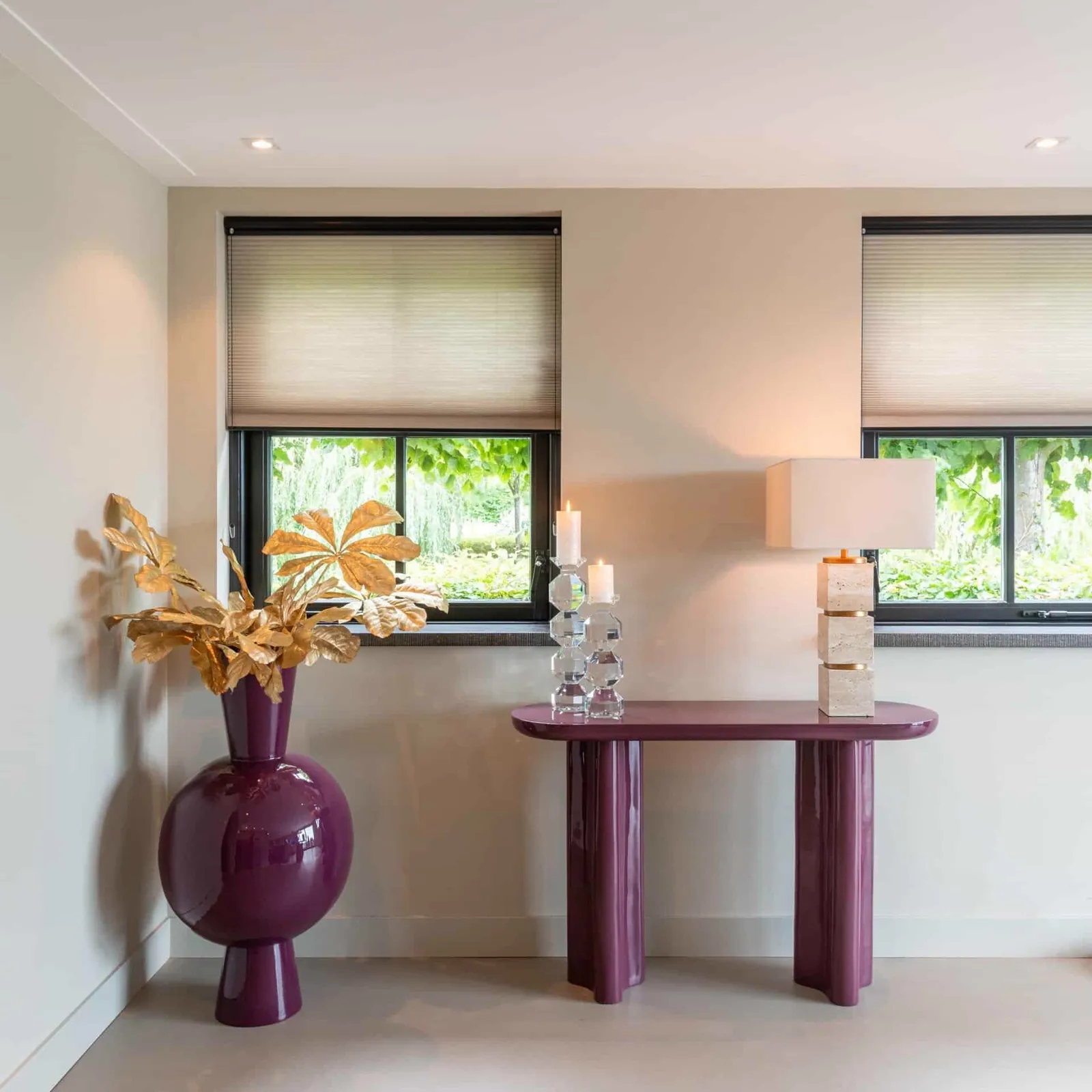 Tischleuchte Jaella beige auf einem lila Beistelltisch in einem hellen Wohnzimmer mit Fenstern - Richmond Interiors