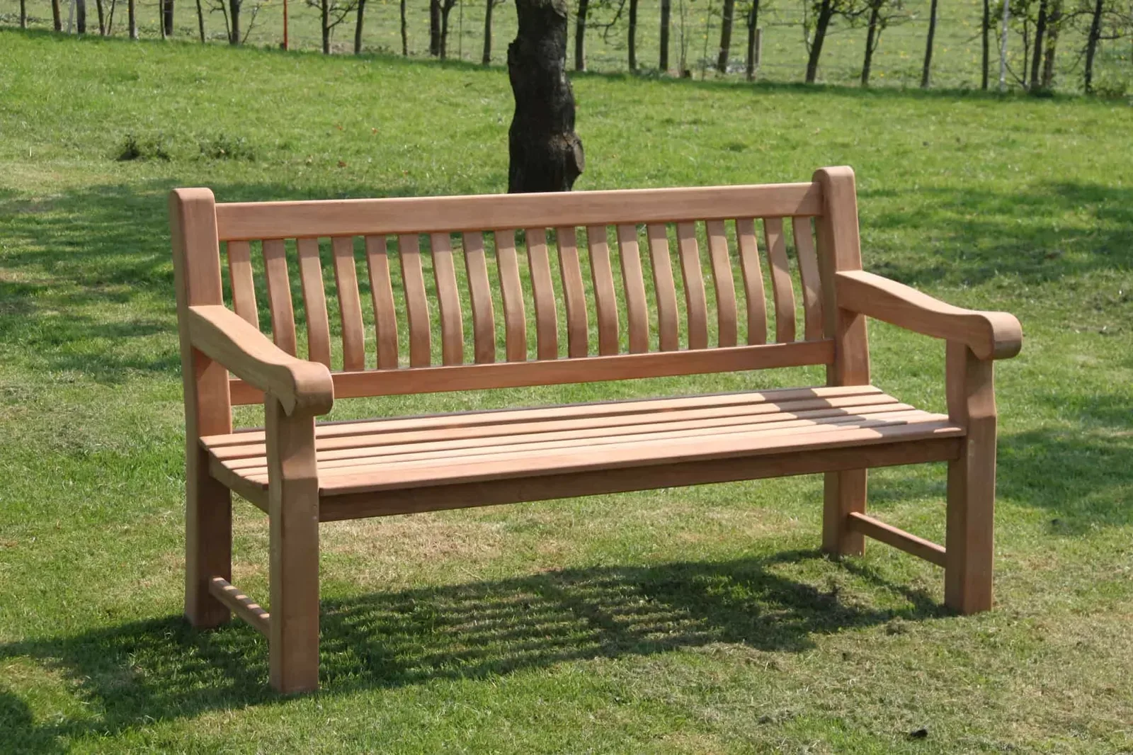 Gartenbank Patrick Fat 166 cm in einem grünen Garten mit Bäumen im Hintergrund - Livingfurn