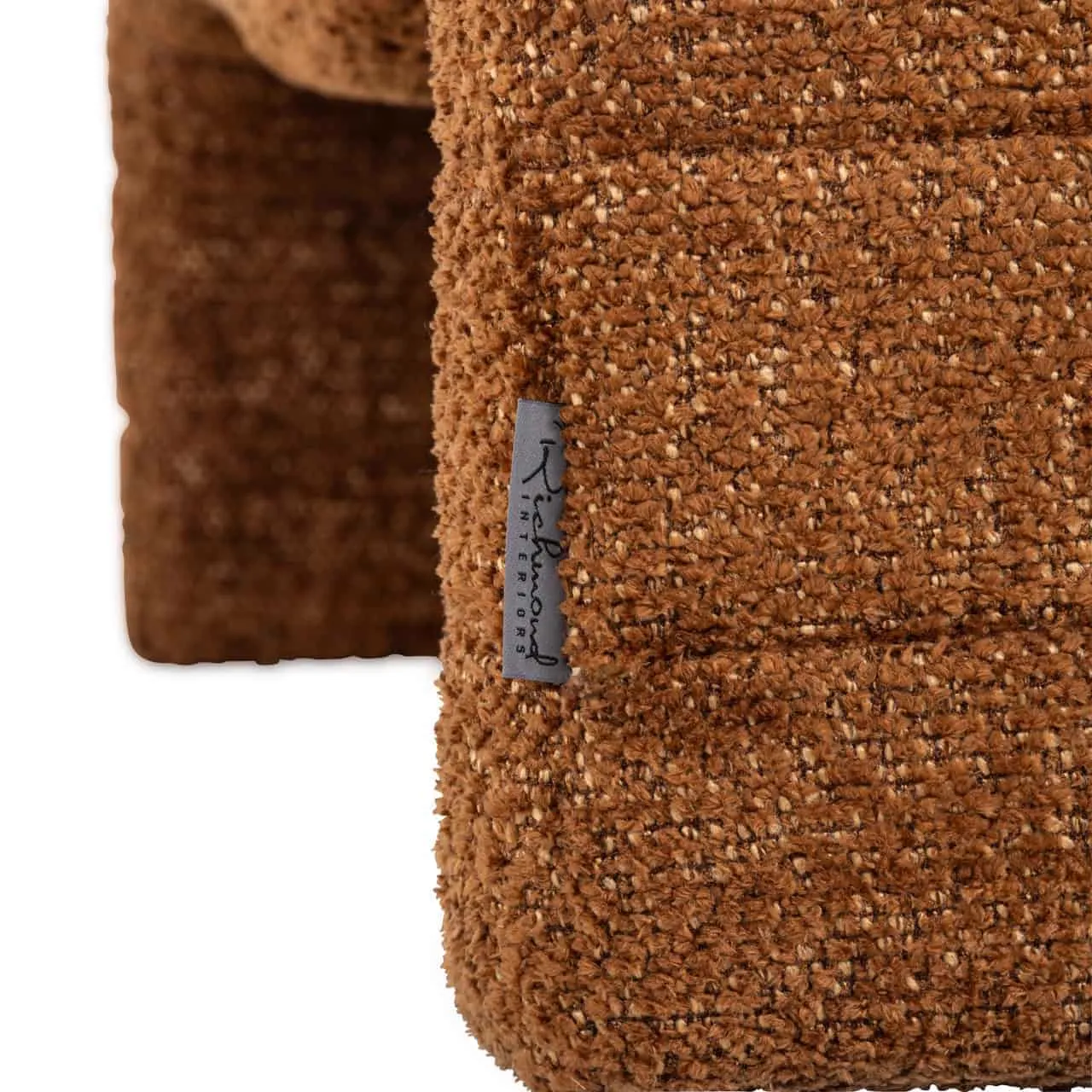 Detail van de Lounge stoel Kelly lovely cinnamon, met een close-up van de stof en het merklabel - Richmond Interiors