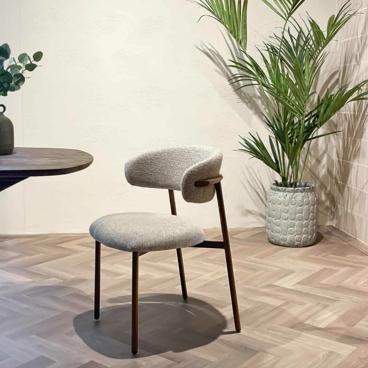 Esszimmerstuhl Micah Hush Walnut in einem Interieur mit Holzfußboden und Pflanzen, schräg von vorne fotografiert - Livingfurn