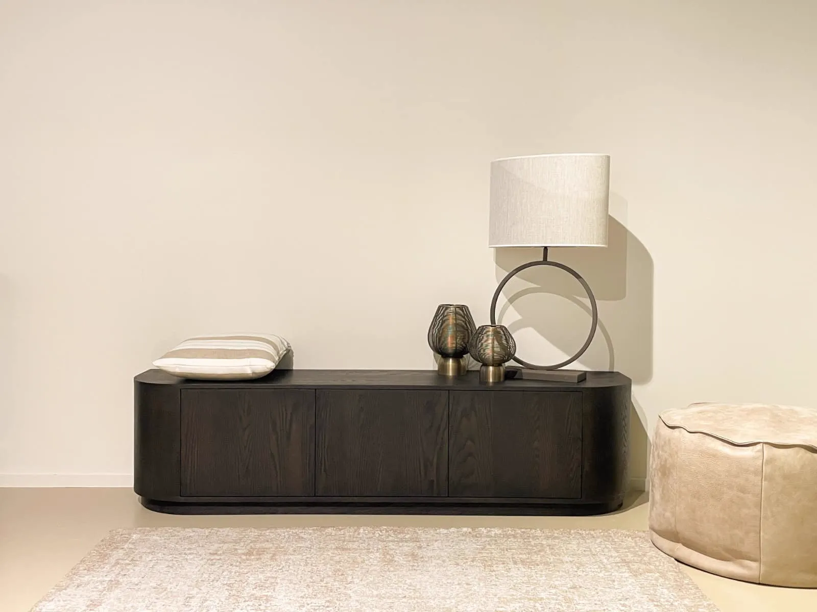 TV meubel Novero Espresso 180cm in een sfeervolle setting met een lamp, kussens en poef - Livingfurn