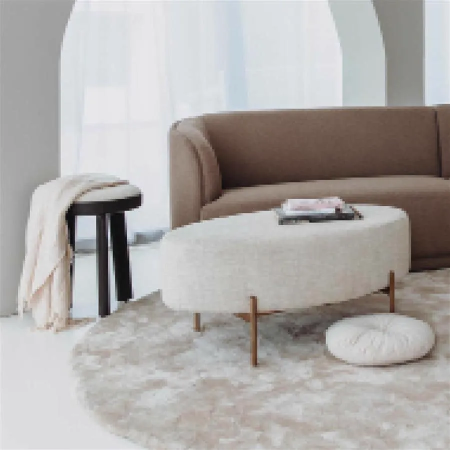 Ossana Hocker rund 40 cm mit einer Decke in einem hellen Wohnzimmer neben einem Sofa und Couchtisch - Tower Living