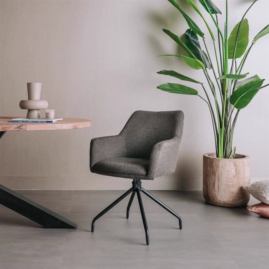 Der Ortana Armstuhl - Alpine dark brown 18 (drehbar) in einem modernen Wohnzimmer mit einer Pflanze und einem runden Tisch - Tower Living