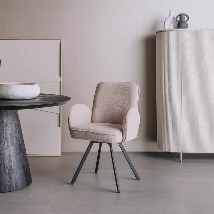 Der Livo Armstuhl - Stoff Ascot 12 Beige (drehbar) steht in einem modernen Wohnzimmer neben einem runden Tisch - Tower Living