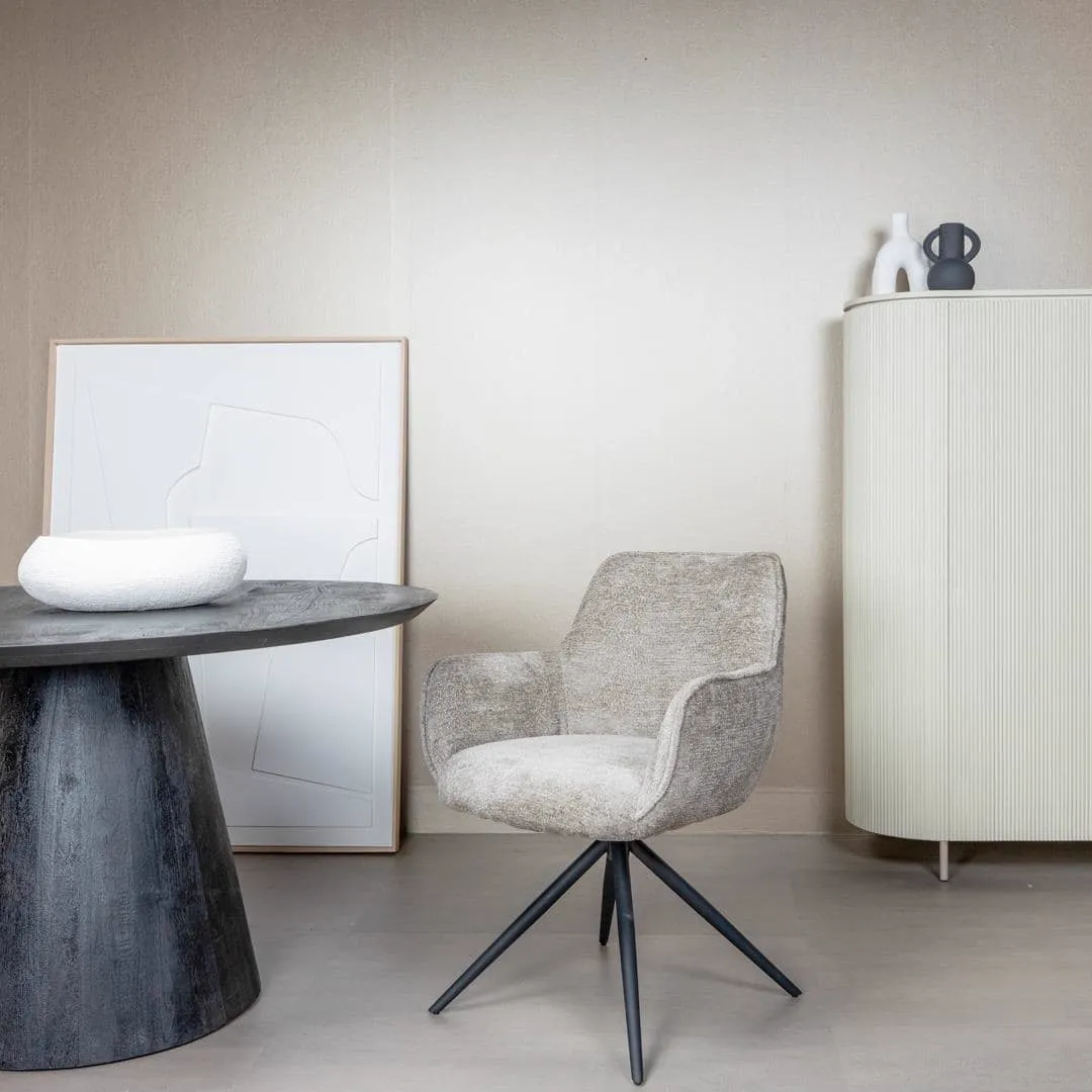 Fondo Armstuhl aus taupefarbenem Stoff, drehbar, steht in einem modernen Interieur neben einem dunklen Tisch - Tower Living