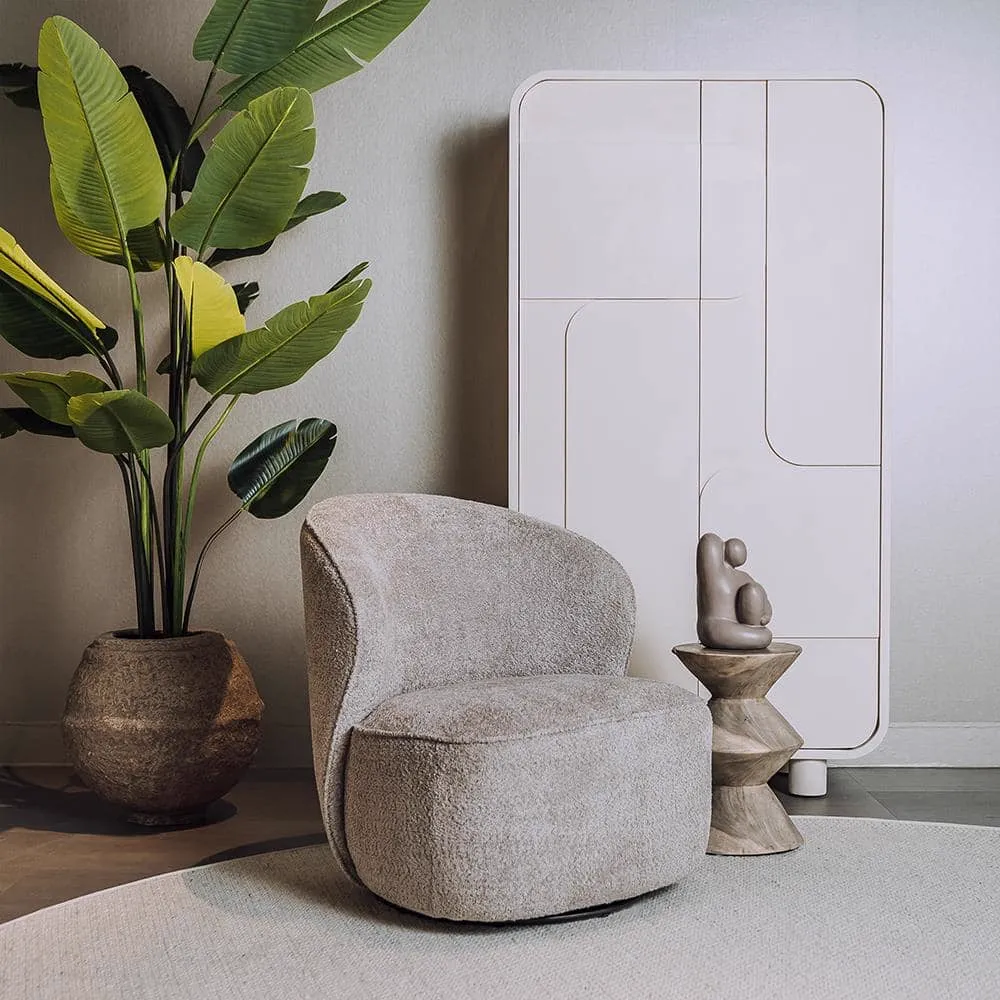Belvi Sessel aus beigem Stoff, drehbar, in einem modernen Interieur mit Pflanze und Schrank - Tower Living