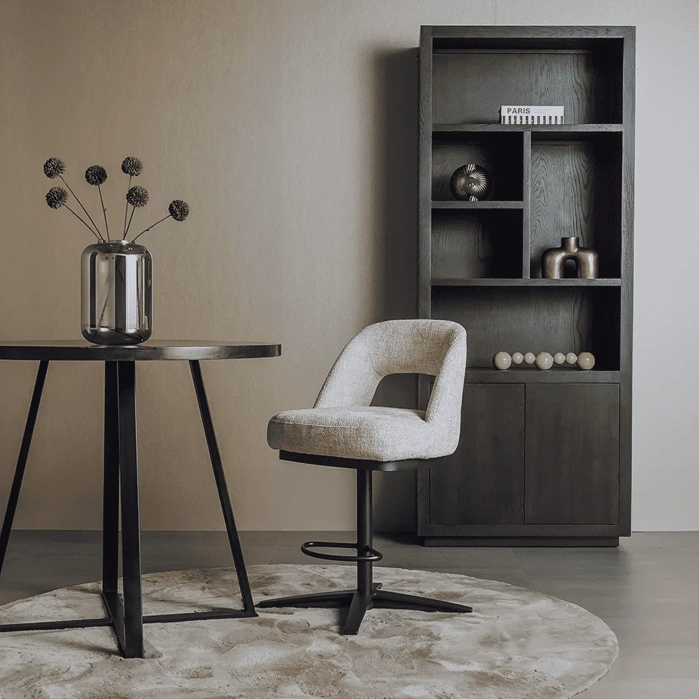Caldes Barstoel in off-white stof, draaibaar, aan een hoge tafel in een modern interieur - Tower Living