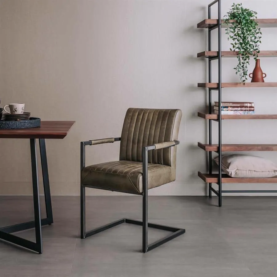 Der Ferro Armstuhl - Stoff Savannah green steht in einem modernen Wohnzimmer neben einem Holzesstisch - Tower Living