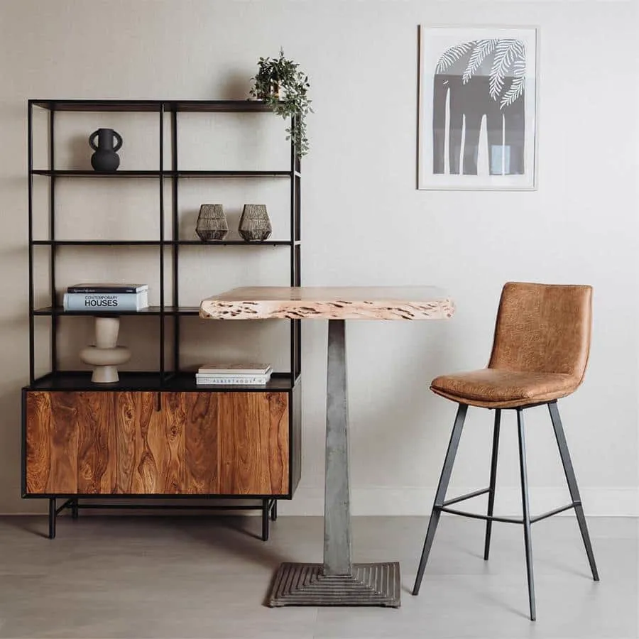 De Pamplona Barstoel - fabric Cognac staat in een modern interieur met een houten tafel en open kast - Tower Living