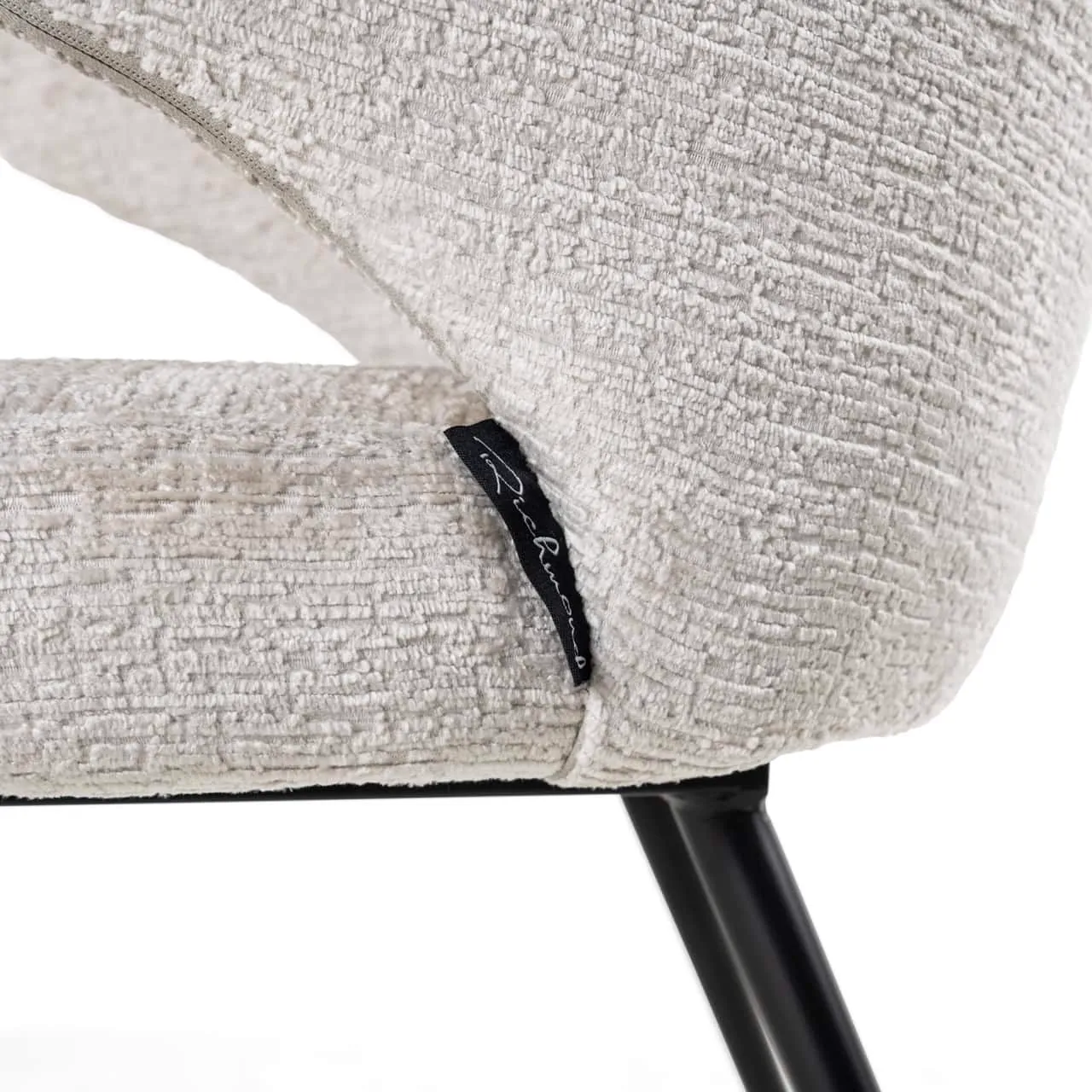 Detail van eetkamerstoel Xandra cream fusion, met de textuur van de stof en het Richmond Interiors label