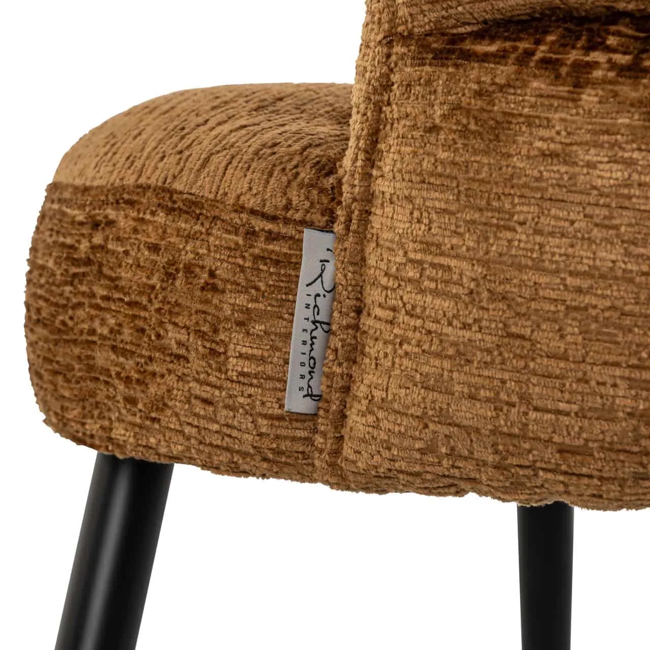 Detailaufnahme der Sitzfläche des Esszimmerstuhls Stella Cognac Fusion, mit einem Etikett von Richmond Interiors