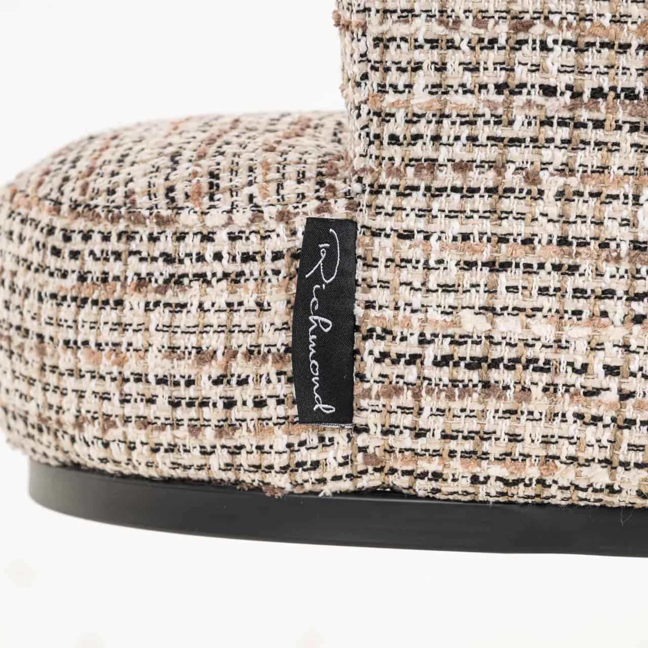 Close-up van de eetkamerstoel Rochenne trendy nature swivel on wheels, met focus op de stof en het merklabel - Richmond Interiors