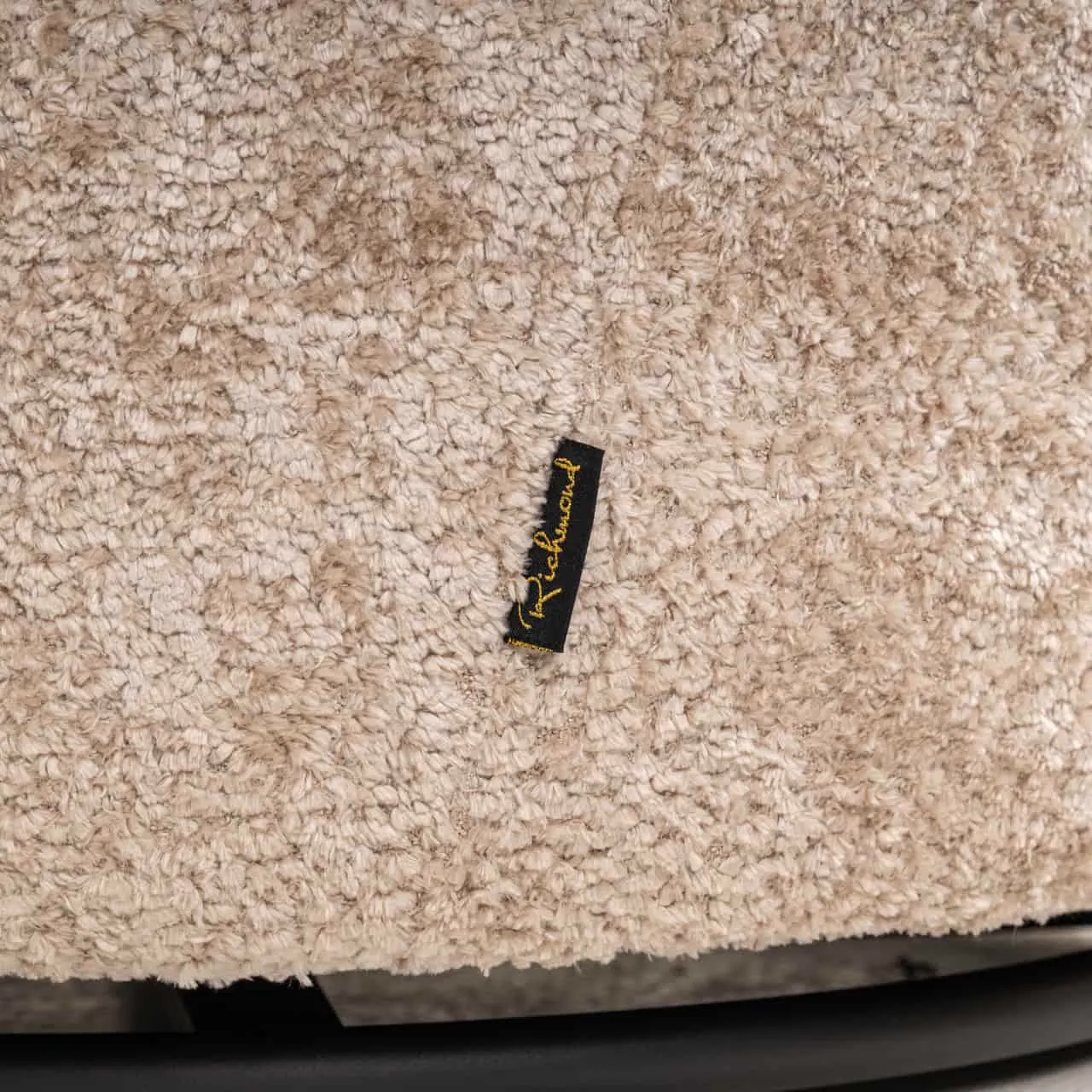 Detail des Loungesessels Jackie Sheep Natural Swivel für Kinder, Nahaufnahme des weichen Stoffes und des Richmond-Etiketts - Richmond Interiors