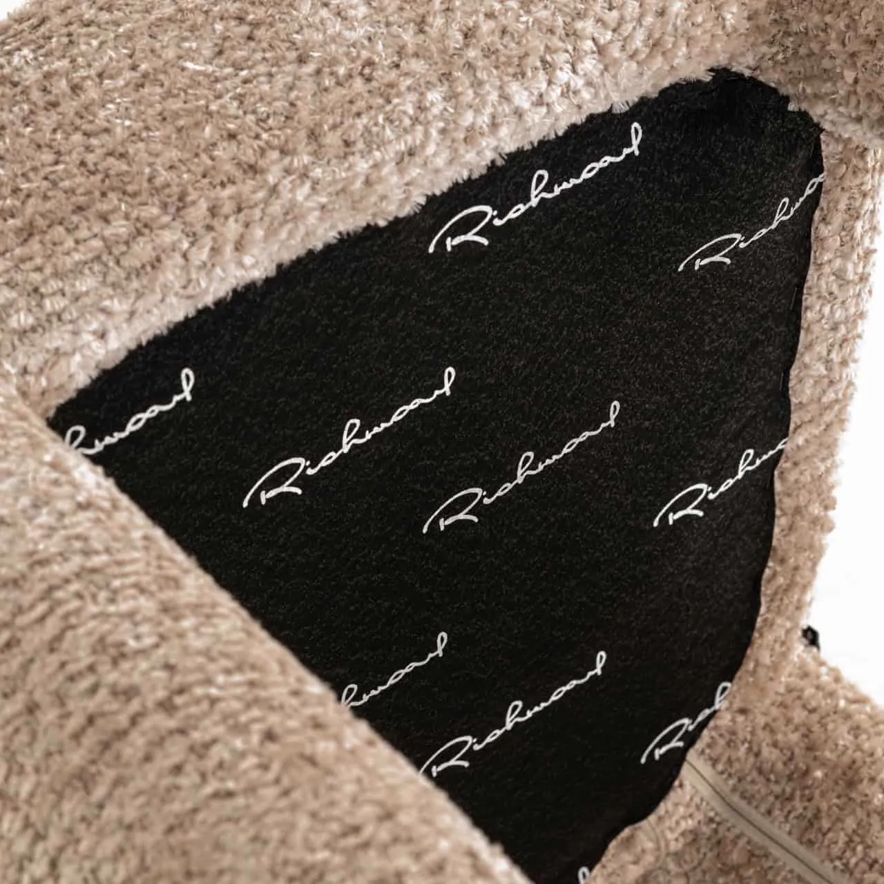 Nahaufnahme des beigen Stoffes des Esstuhls Brandi lovely beige, mit einem schwarzen Etikett mit der Aufschrift 'Richmond' - Richmond Interiors