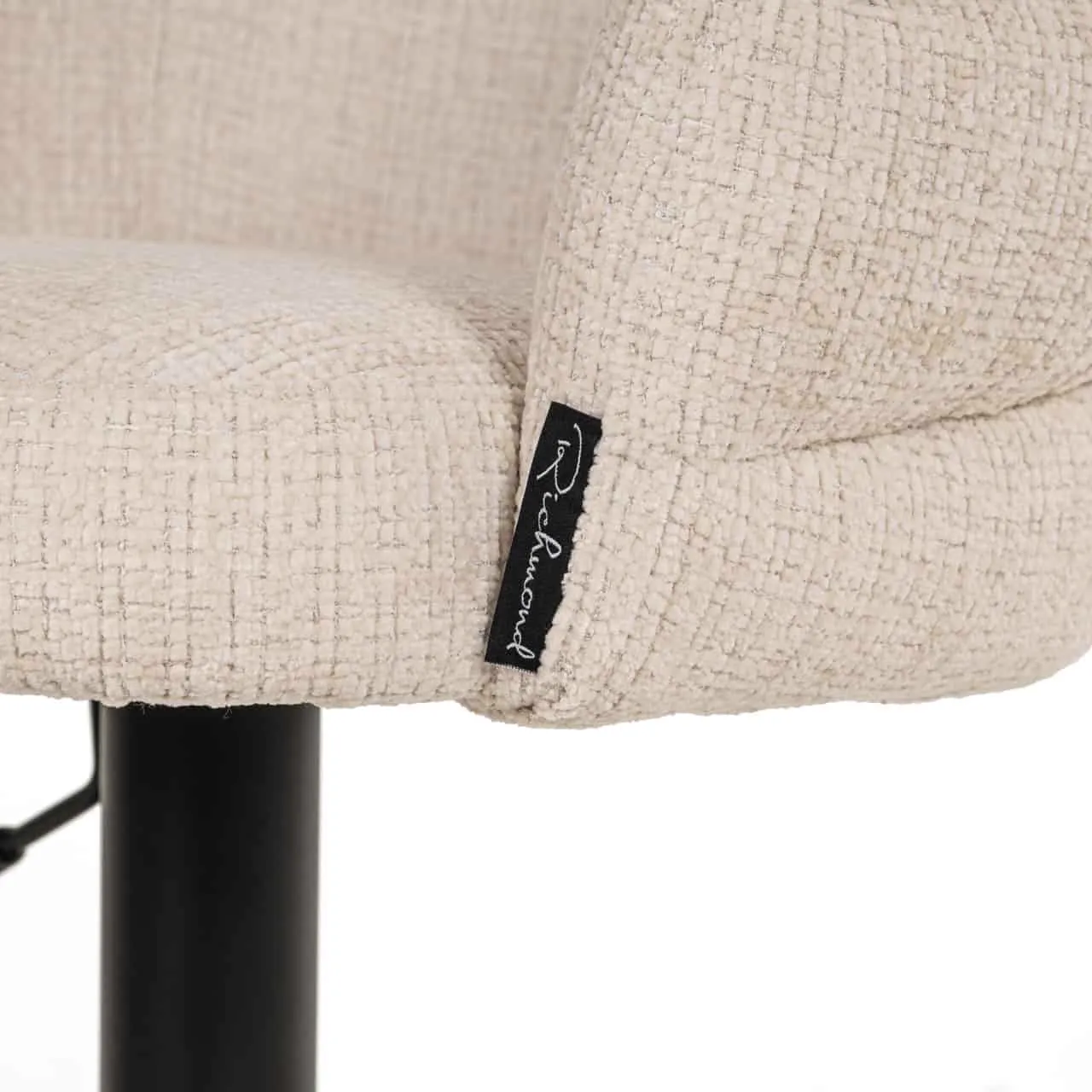 Nahaufnahme des beigefarbenen Stoffbezugs des Barhocker Nikki Niagara Beige Swivel Fire Retardant mit Markenetikett - Richmond Interiors