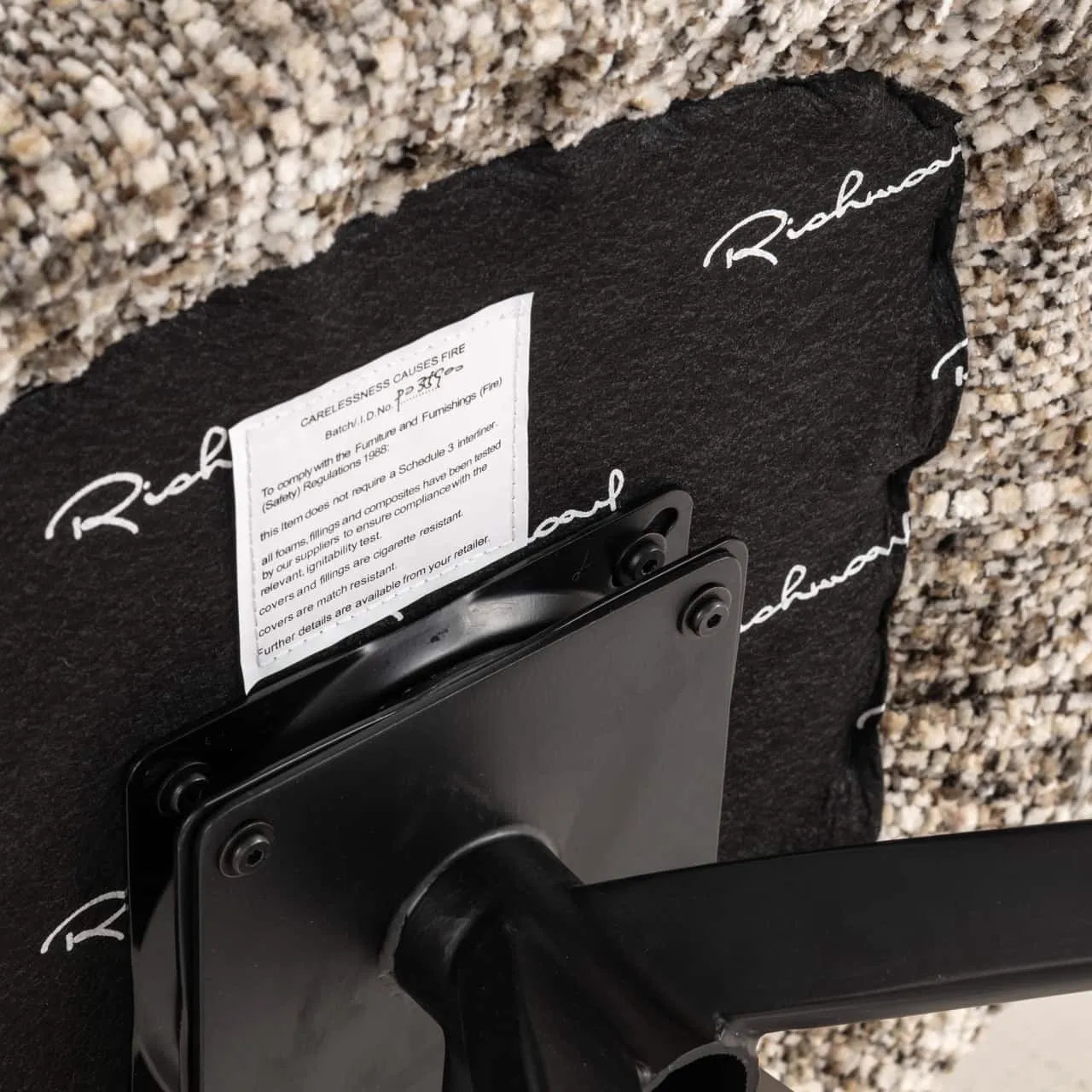 Nahaufnahme der Unterseite des Esszimmerstuhls Serenity brown omara swivel fire retardant, mit Etikett und Drehmechanismus - Richmond Interiors