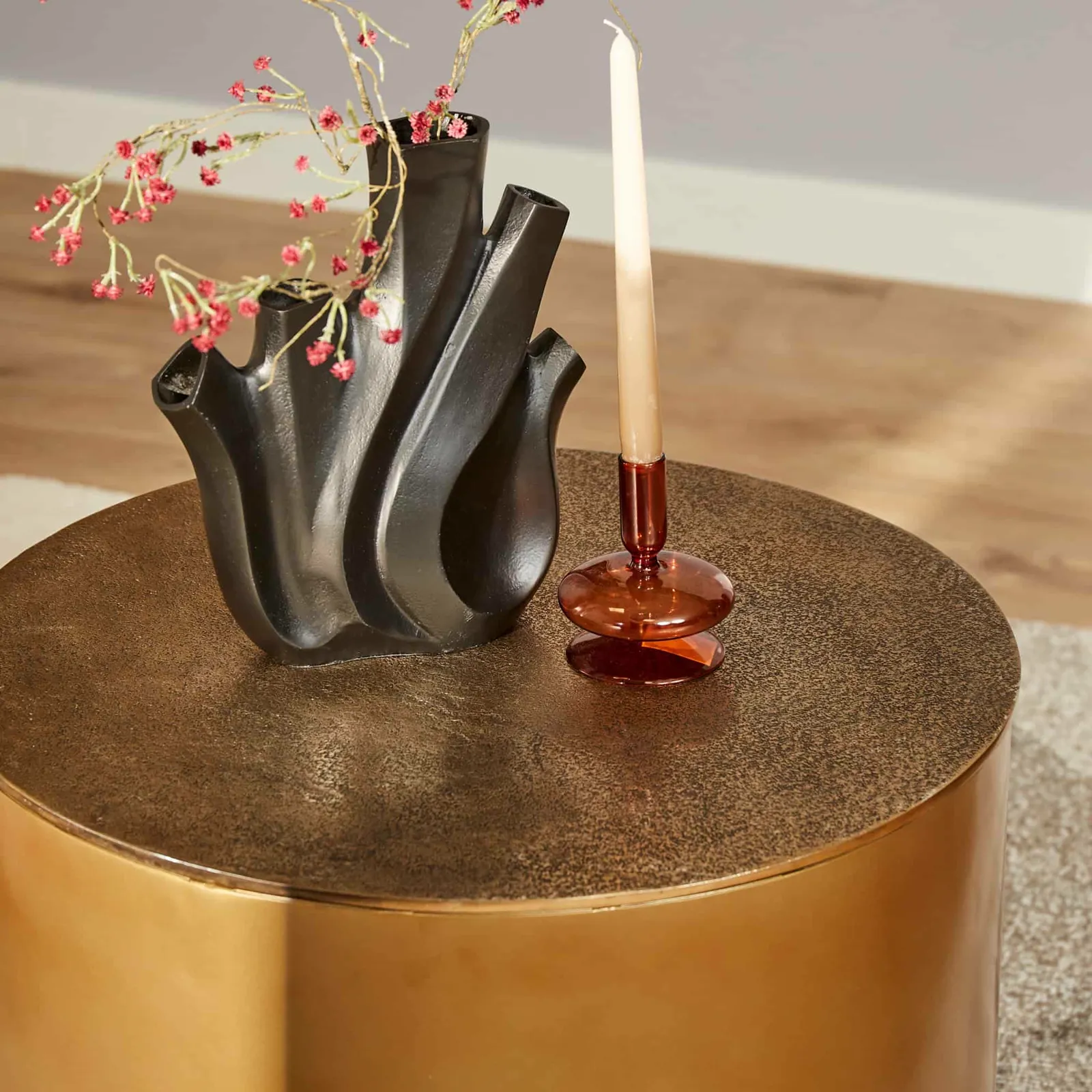 Couchtisch Fiore Gold von oben gesehen mit einer schwarzen Vase mit roten Blumen und einer Kerze - Starfurn
