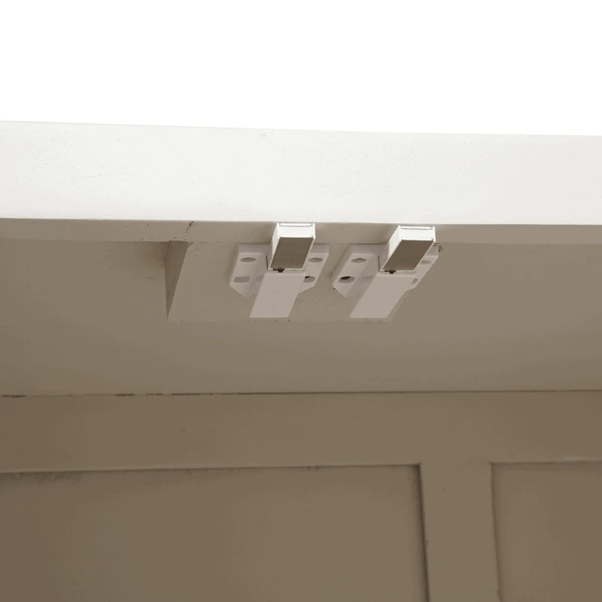 Detailaufnahme der zwei weißen magnetischen Türverschlüsse an der Innenseite des Sideboard Brüssel Sand Mangoholz - Starfurn