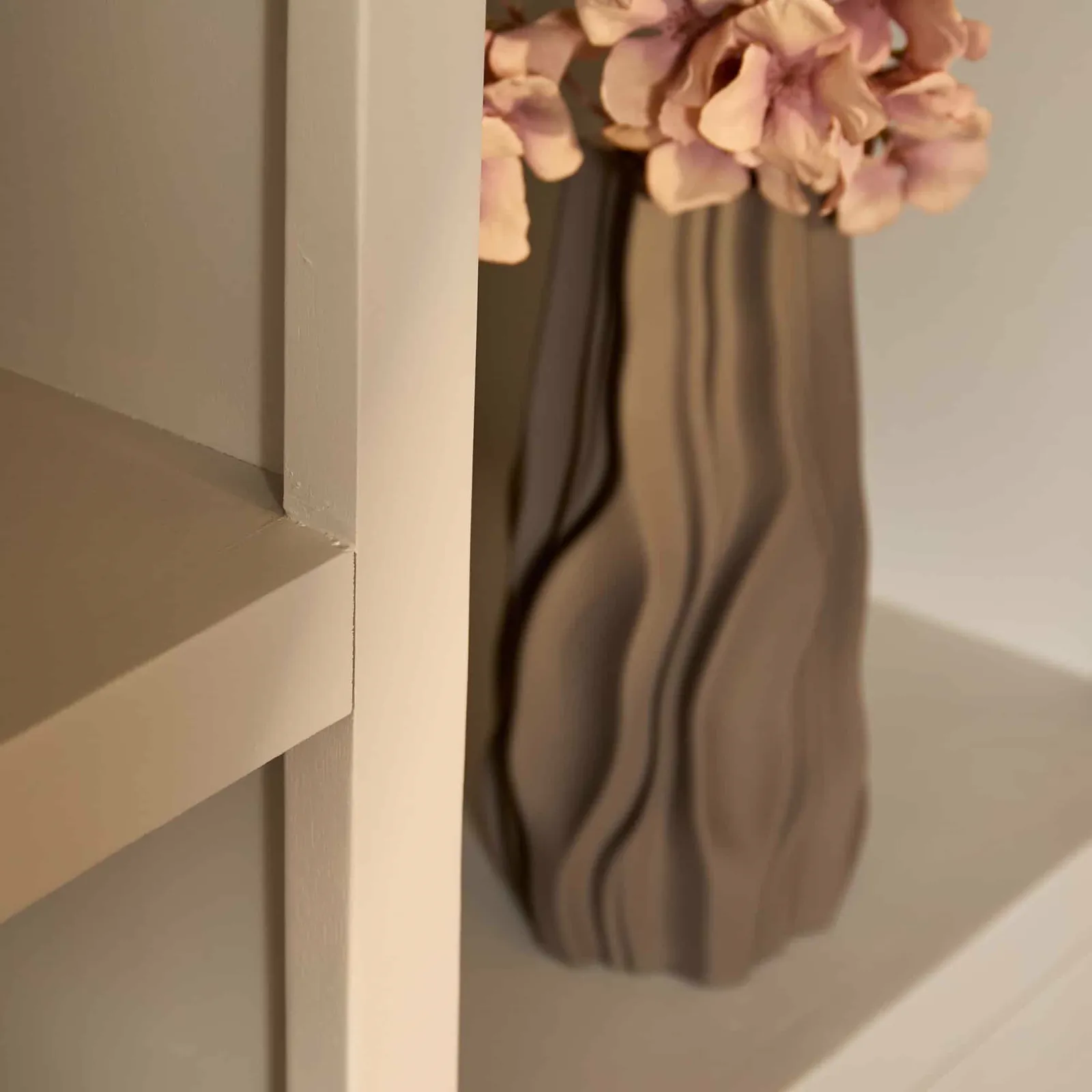 Detailaufnahme des Regalbrett Brüssel Sand XL, mit einer Vase mit Blumen auf einem der Regalböden - Starfurn