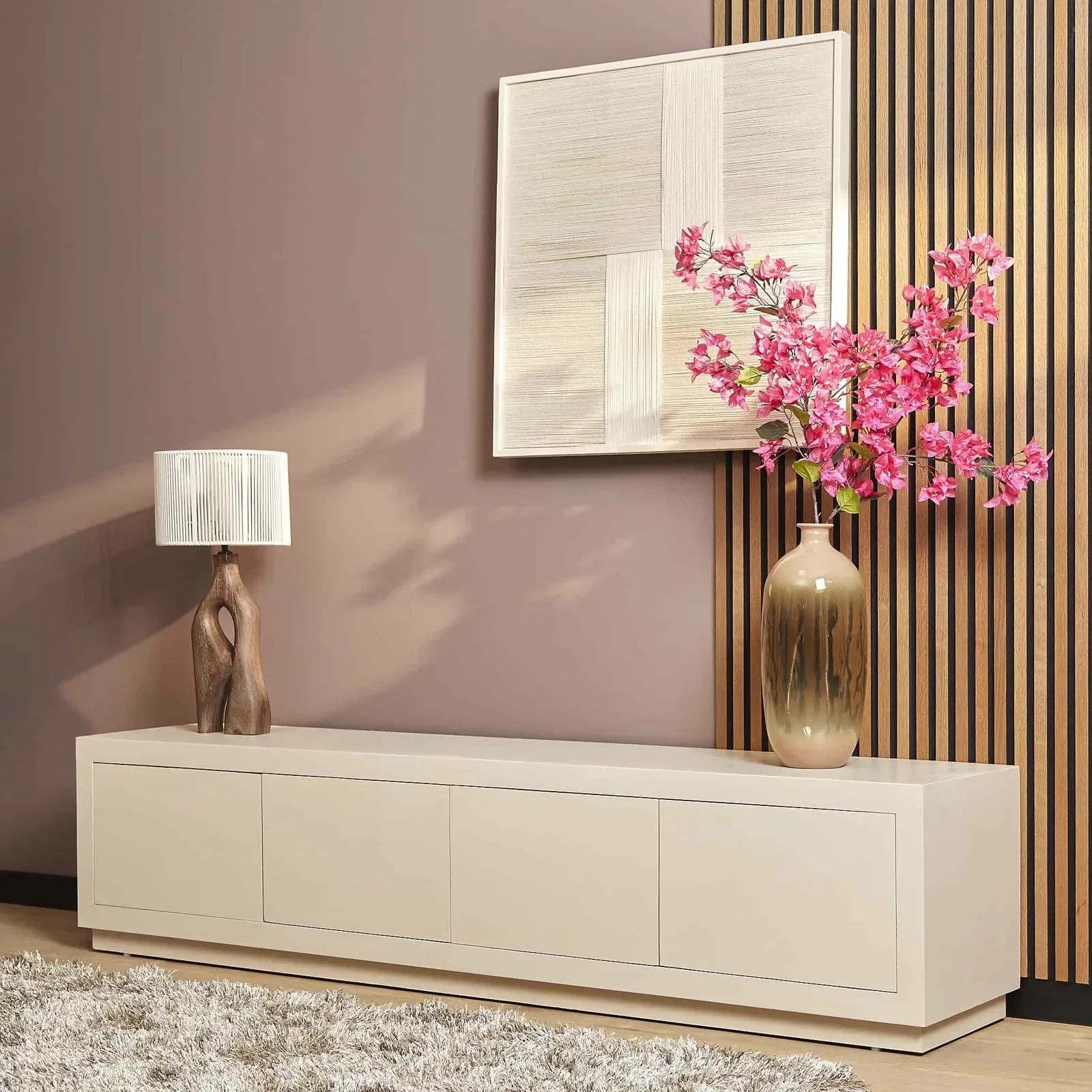 TV-Schrank Brüssel Sand in einem Wohnzimmer-Ambiente mit Lampe, Kunstwerk und rosa Blumen - Starfurn