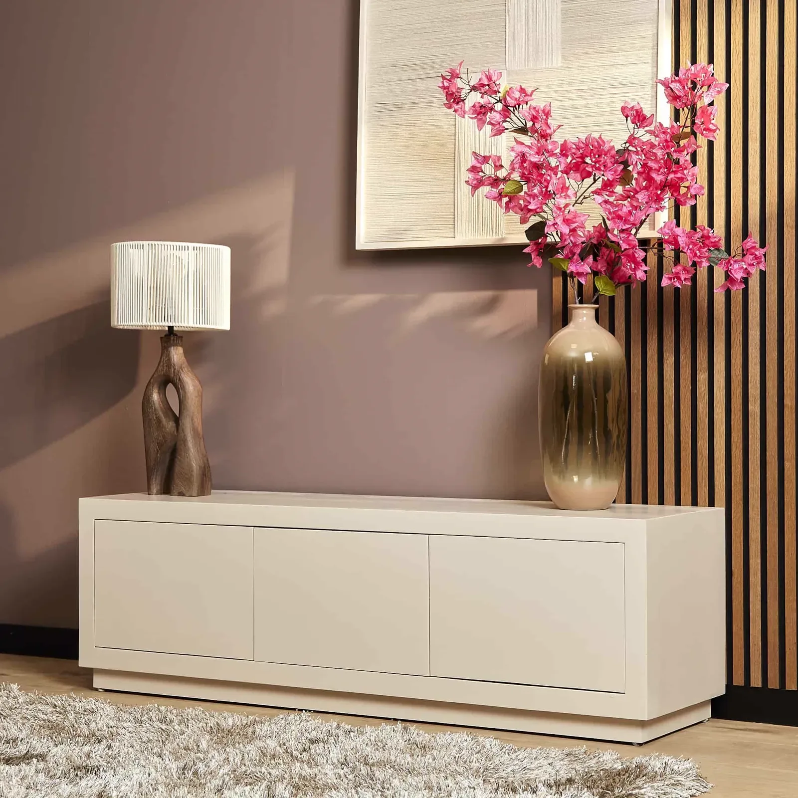 TV-Möbel Brussel Sand in einer Wohnzimmerumgebung mit einer Lampe, Vase und rosa Blumen - Starfurn