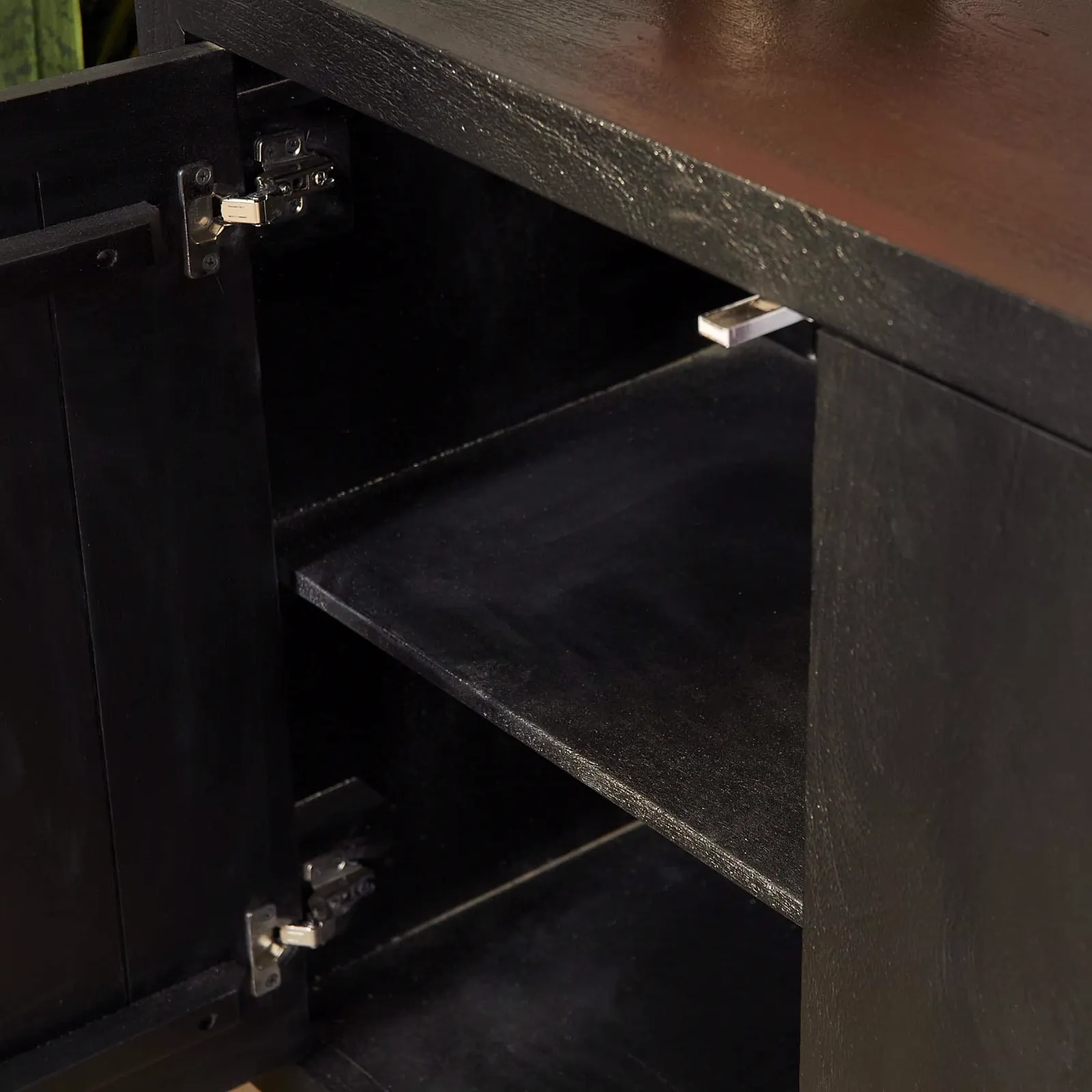 Detailansicht des Sideboard Brüssel Schwarz Mangoholz 200 cm, mit einer geöffneten Schranktür und einem Regalbrett - Starfurn