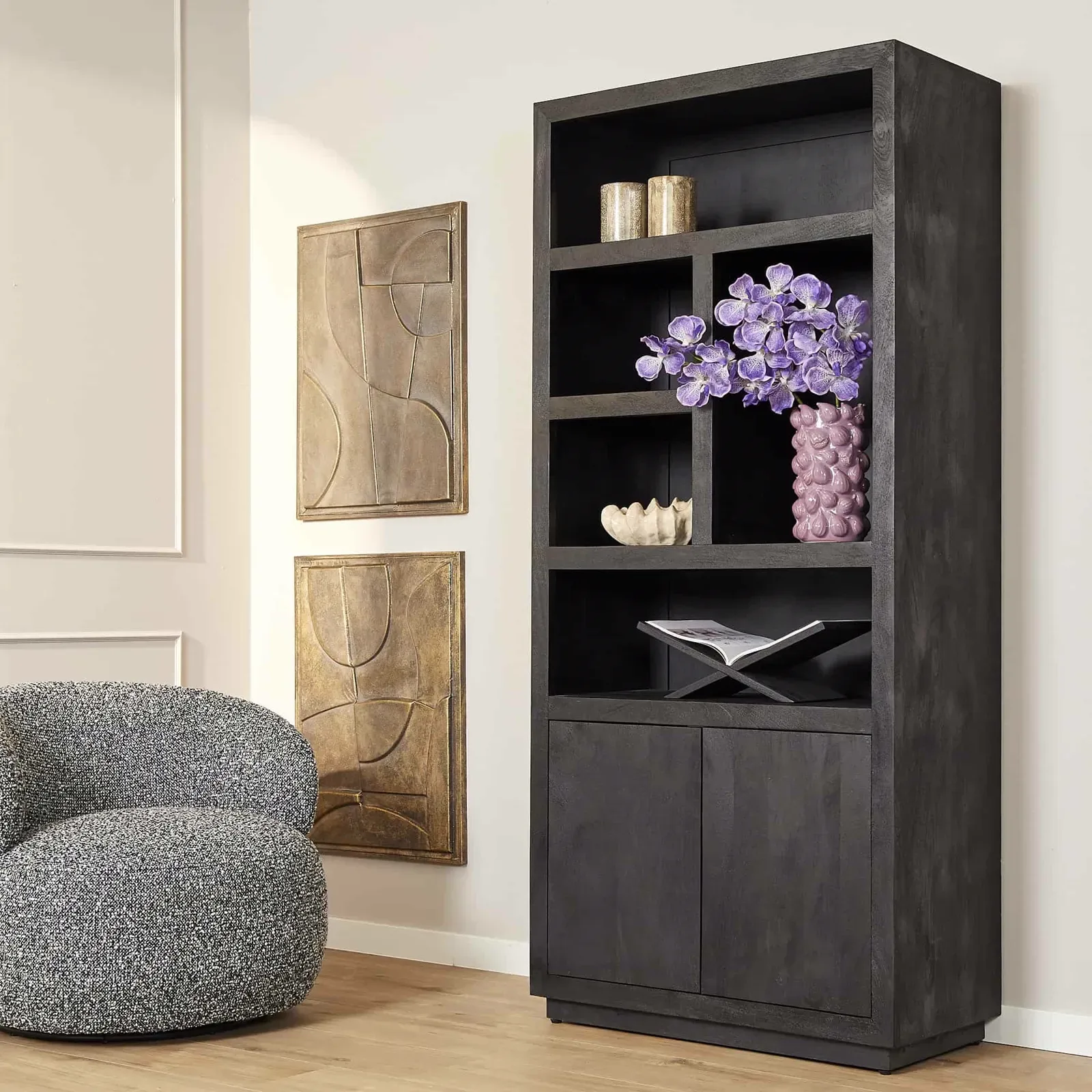 Regalsystem Brüssel Black in einem stilvollen Wohnzimmer, dekoriert mit Accessoires und einem Sessel daneben - Starfurn