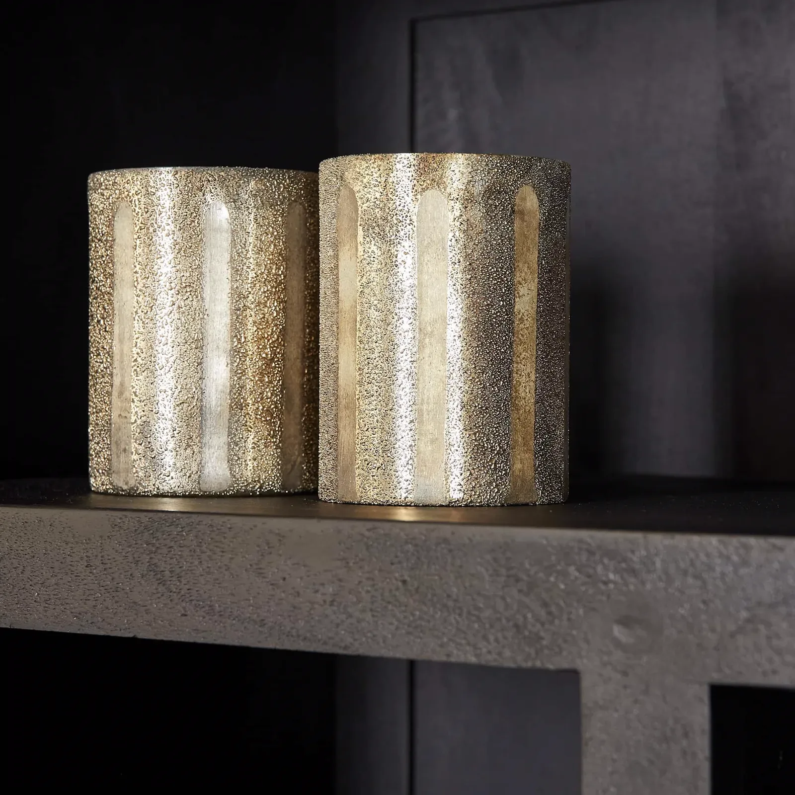 Nahaufnahme von zwei goldenen, glitzernden Vasen auf einem Regal des Regalsystems Brüssel Black - Starfurn