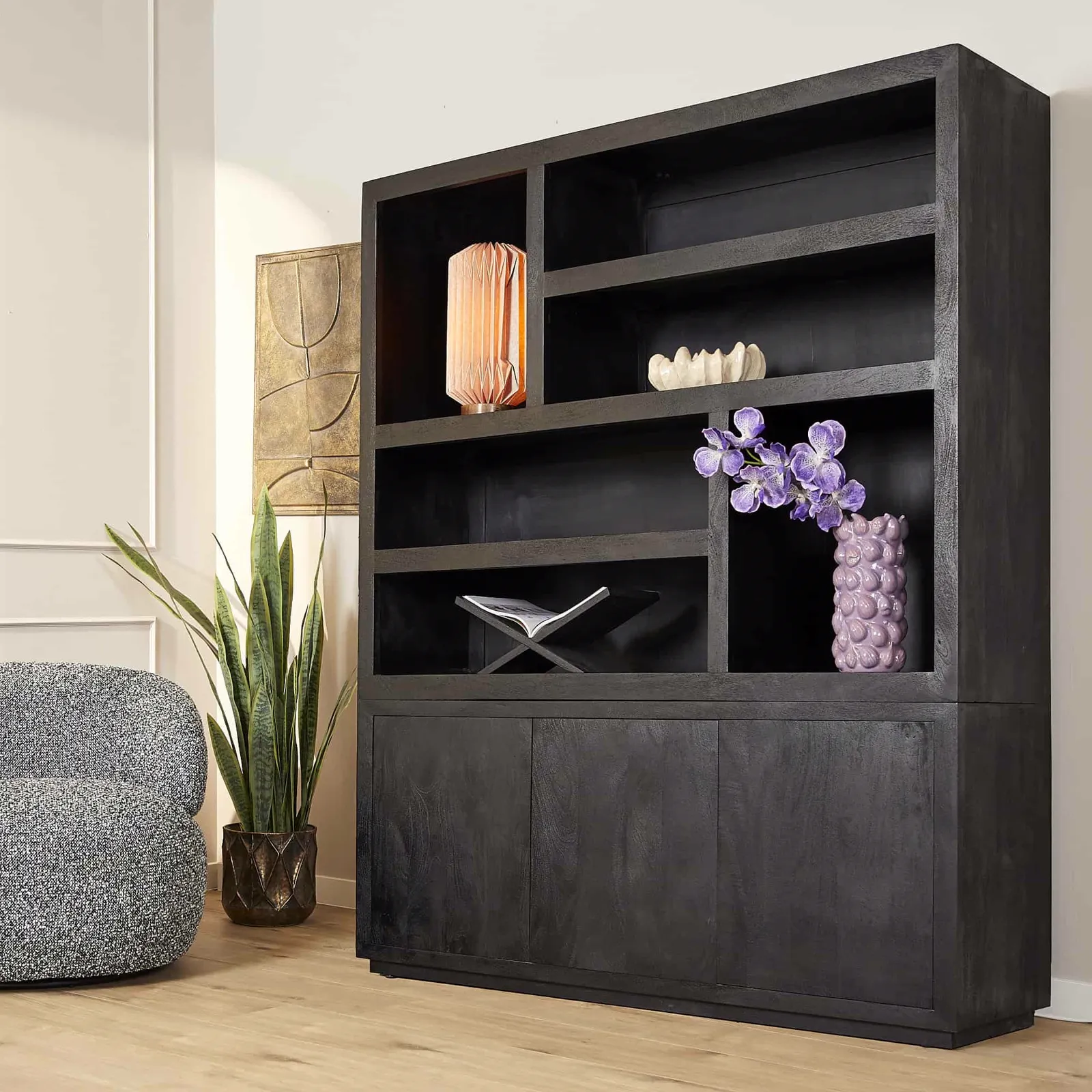 Fächerregal Brüssel Black XL in einem Wohnzimmer-Ambiente, mit verschiedenen Dekorationen und einer Pflanze daneben - Starfurn