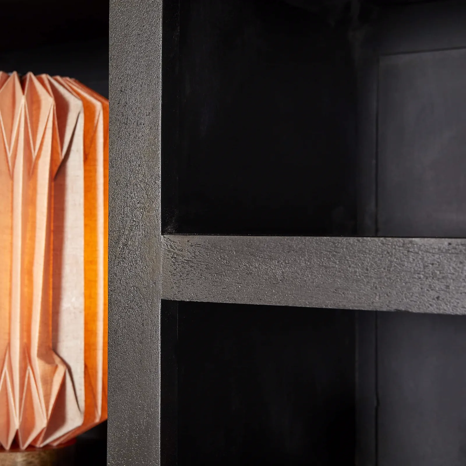Detail des Fächerregals Brüssel Black XL, mit einer Nahaufnahme der schwarzen Holzregale und einer orangefarbenen Lampe - Starfurn