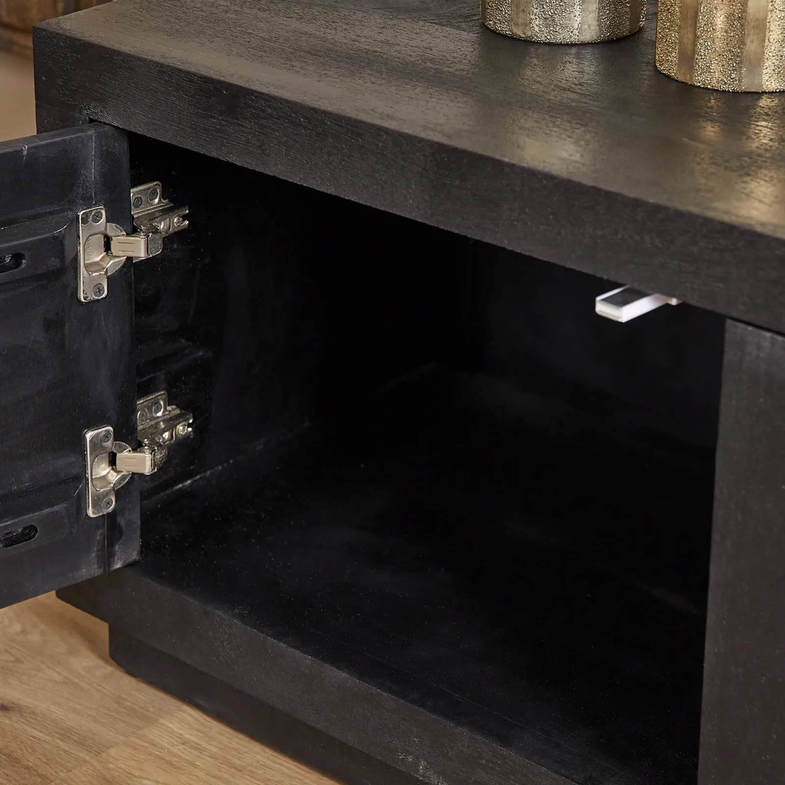 Detailaufnahme des TV-Schrank Brüssel Black, eine offene Tür mit Scharnieren und die dunkle Innenseite - Starfurn
